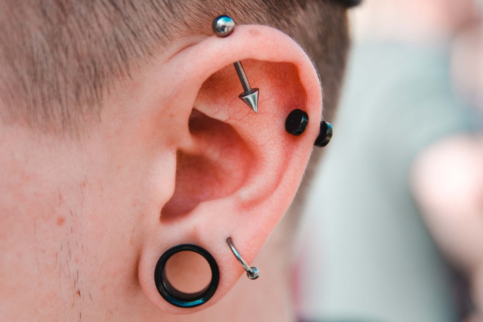 Muž s mnoha piercingy v uchu