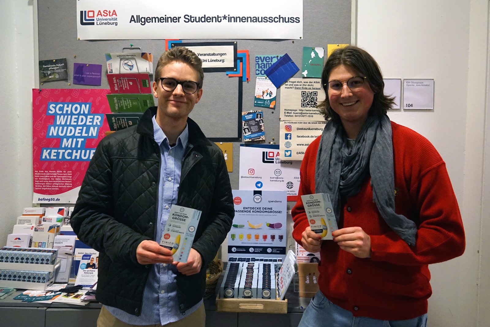 Luis ze společnosti Spondoms (vlevo) spolu s Maxem z AStA Leuphanské univerzity v Lüneburgu (vpravo) otevírají automat na kondomy zdarma.