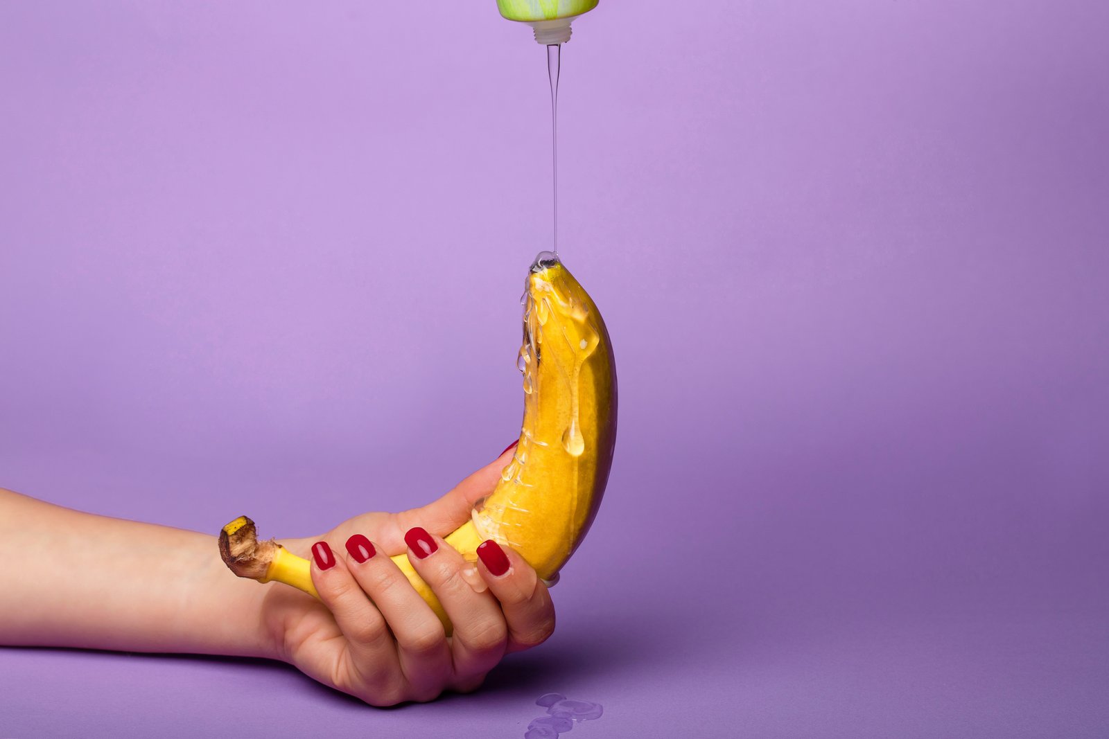 Mazivo se přelije přes banán držený jednou rukou.